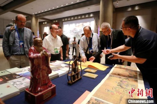 中外嘉宾在会场内翻阅中国典籍。梁犇 摄   中外嘉宾在会场内翻阅中国典籍。梁犇 摄